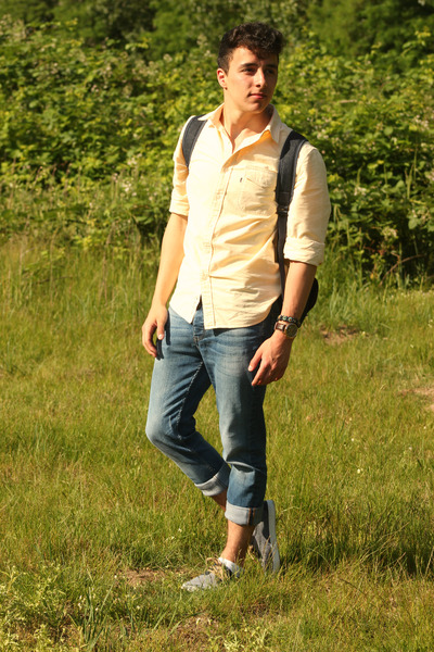 yellow shirt and light blue jeans